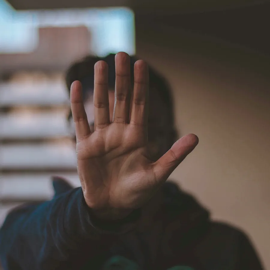 Persona con la mano abierta frente a su rostro